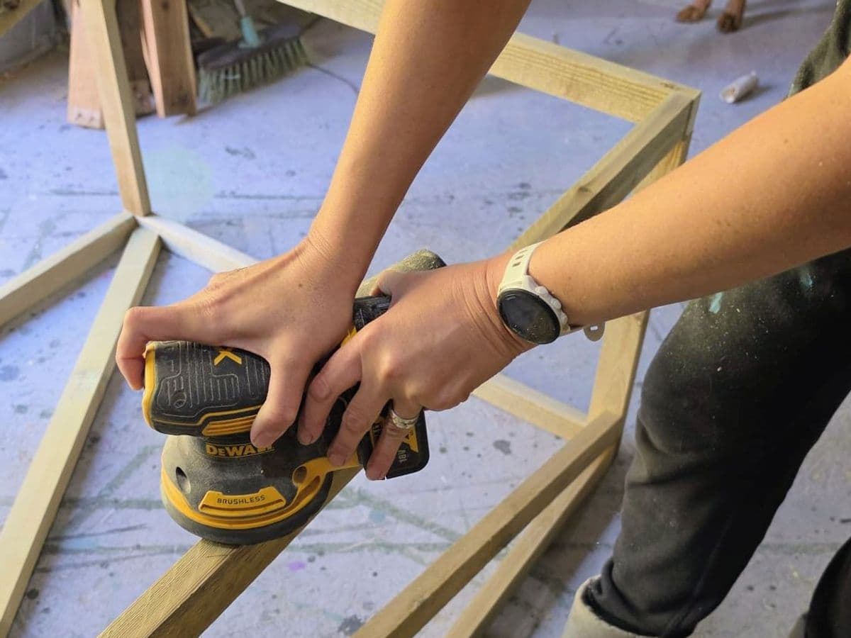 Chris sanding a timber frame in the workshop